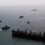 Imagen de una reunión de funcionarios de Estados Unidos y China con banderas de ambos países de fondo