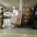 Imagen de una persona sosteniendo un letrero de 'Derechos Humanos' en un contexto de conflicto y pobreza