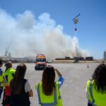Imagen de un incendio en una zona industrial con humo negro saliendo de contenedores y materiales en llamas