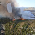 Imagen de un incendio forestal en una zona rural de Málaga, con bomberos trabajando en la extinción