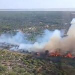 Un helicóptero sobrevuela el paraje Marismillas de Almonte durante la extinción del incendio