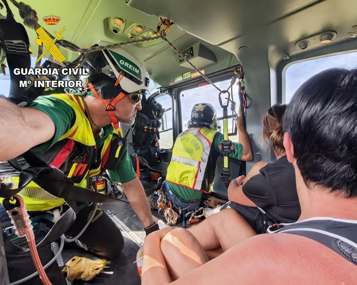 Imagen de un helicóptero de la Guardia Civil rescatando a dos senderistas en una zona montañosa de difícil acceso