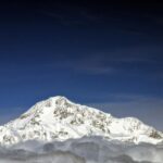 Imagen de un grupo de alpinistas en el Denali, con la montaña más alta de Norteamérica al fondo