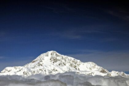Imagen de un grupo de alpinistas en el Denali, con la montaña más alta de Norteamérica al fondo