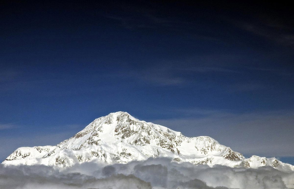 Imagen de un grupo de alpinistas en el Denali, con la montaña más alta de Norteamérica al fondo