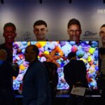 Una persona viendo un partido de fútbol en un televisor con tecnología RGB MiniLED