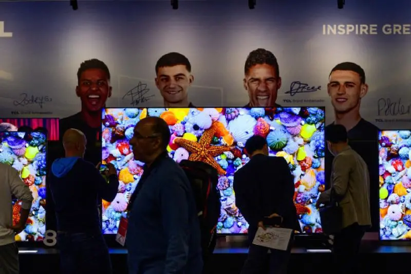Una persona viendo un partido de fútbol en un televisor con tecnología RGB MiniLED