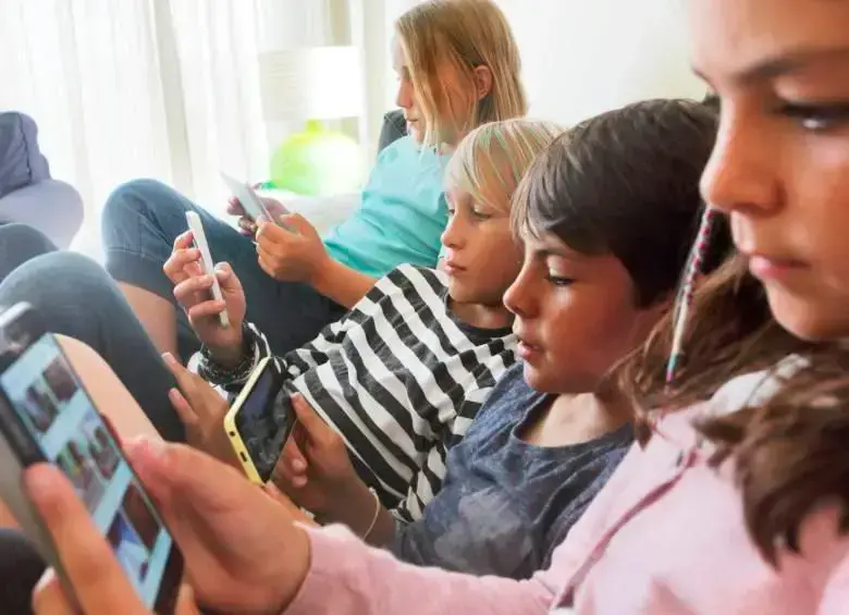 Niños y adolescentes utilizando dispositivos móviles en un entorno seguro y supervisado