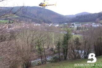 Un tractor volcado en una zona rural con un equipo de rescate trabajando en la zona