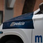 Imagen de un agente de los Mossos d'Esquadra en una calle de Barcelona con un hombre detenido en el suelo