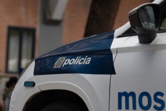 Imagen de un agente de los Mossos d'Esquadra en una calle de Barcelona con un hombre detenido en el suelo