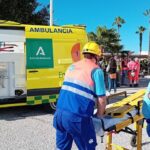 Imagen de un coche en una calle con personas atendiendo a heridos en la terraza de un bar en Frigiliana